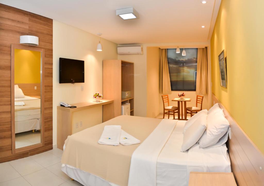 Habitación de hotel con cama y mesa pequeña en Hit Hotel, en Salvador