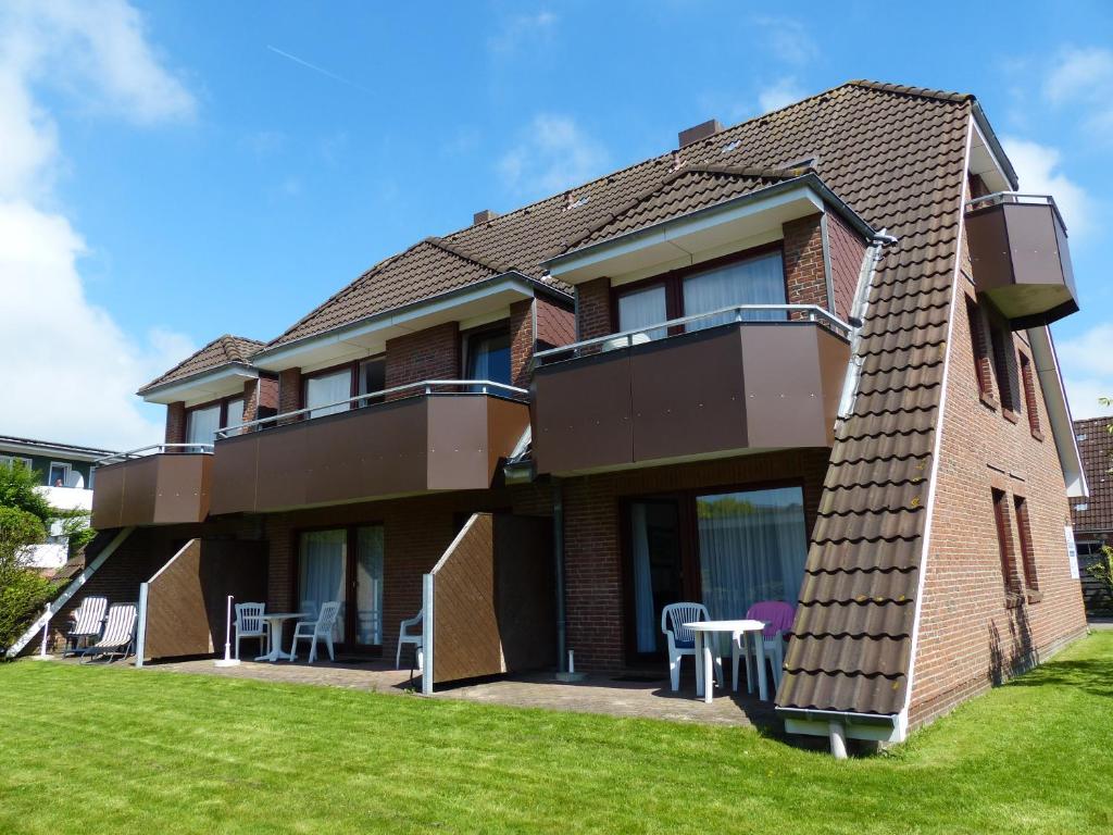 a brick house with a lawn in front of it at Appartementhaus Alt Büsum in Büsum