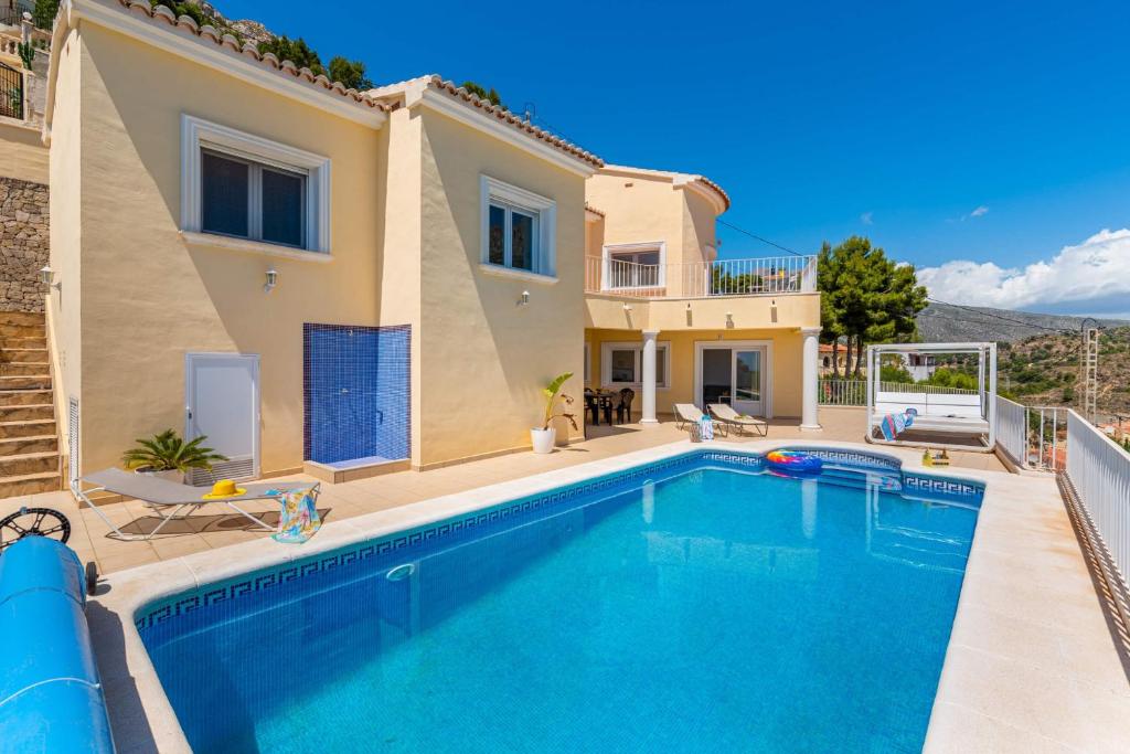 a villa with a swimming pool in front of a house at Villa Orion - Plusholidays in Calpe