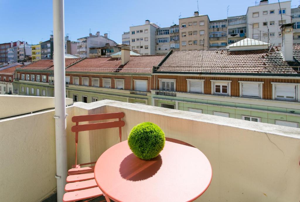 a green plant sitting on a table on a balcony at City Retreat in Lisbon