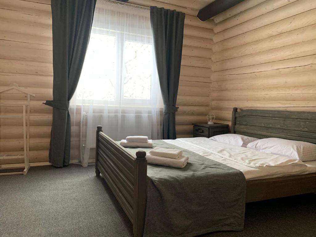 a bedroom with a bed with two towels on it at Villa Olexandr&Matvii in Bukovel