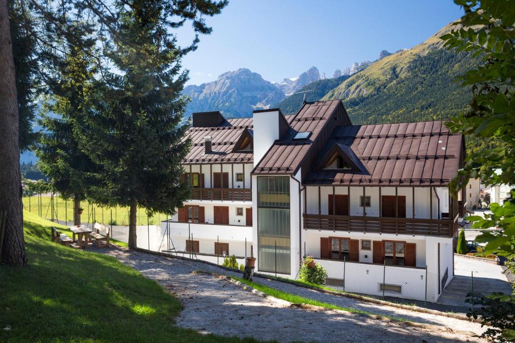 um grande edifício branco com montanhas ao fundo em Residence Diamant em Andalo