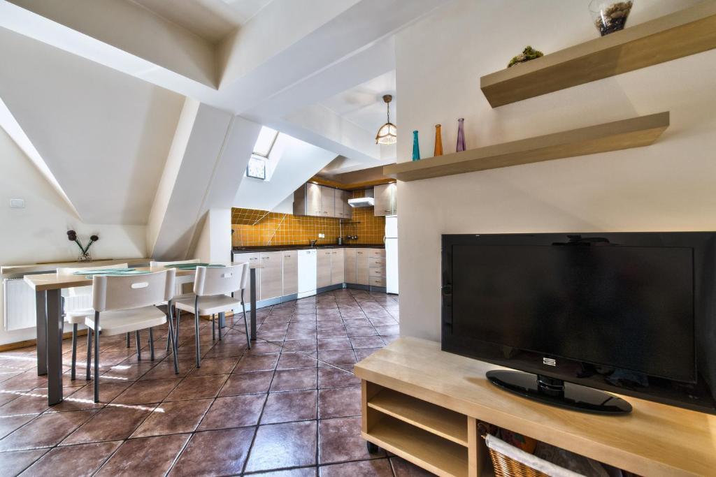 a living room with a large flat screen tv and a table at Apartamenty Sun & Snow Centrum in Zakopane