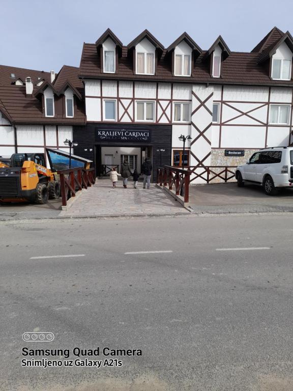 a building on a street with cars parked in front of it at Like Home Lux, Apartman A9 in Kopaonik