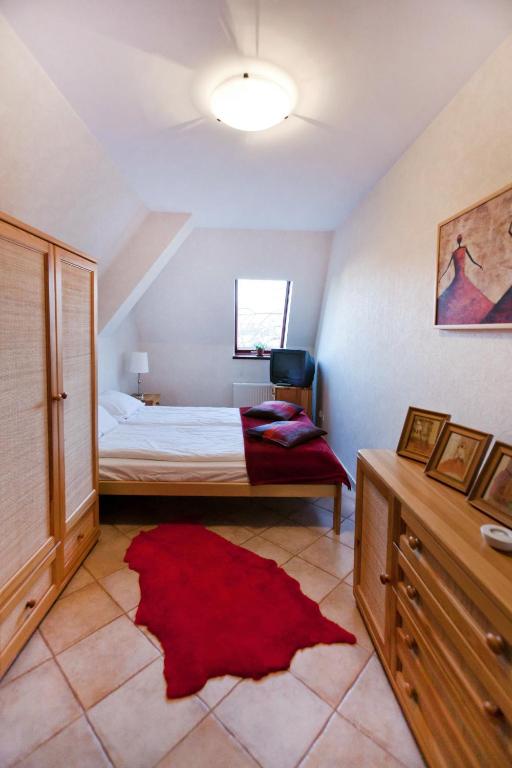 a bedroom with a bed and a red rug at Apartamenty Sun & Snow Centrum in Zakopane