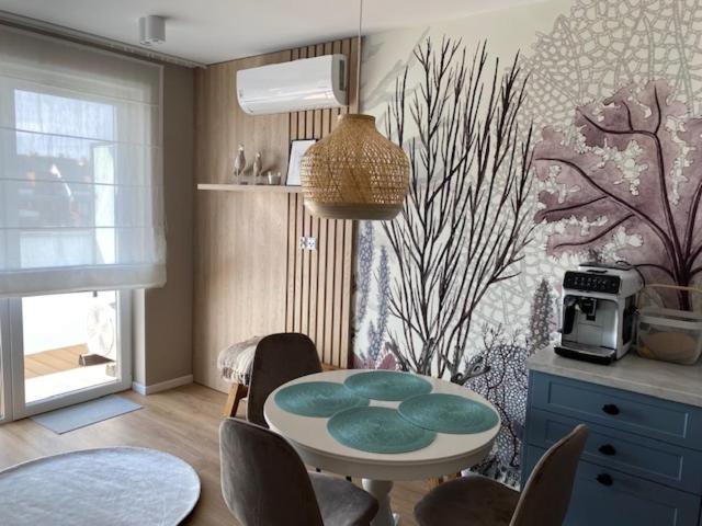 a kitchen with a table and chairs in a room at Baltic Apartment Posesja Kapitańska in Grzybowo