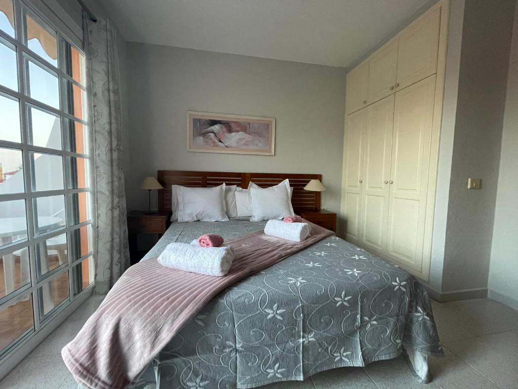 a bedroom with a bed with two dolls on it at Apartamento Gustamar 10 in Caleta De Fuste