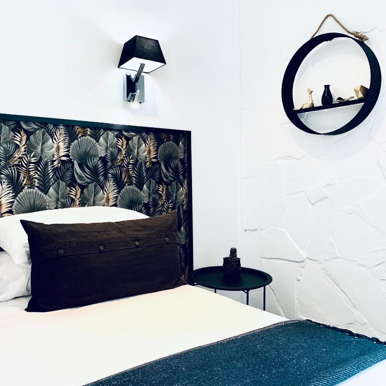 a bedroom with a bed and a mirror on the wall at Hôtel Gaspard in Le Touquet-Paris-Plage