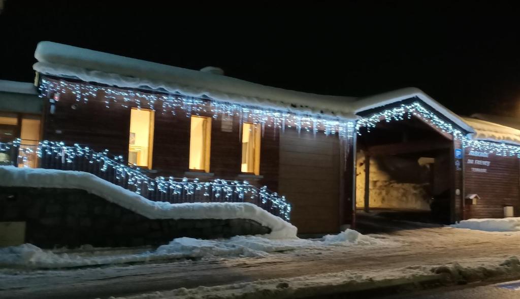 a house covered in christmas lights in the snow at Auberge du Freney in Le Freney-dʼOisans