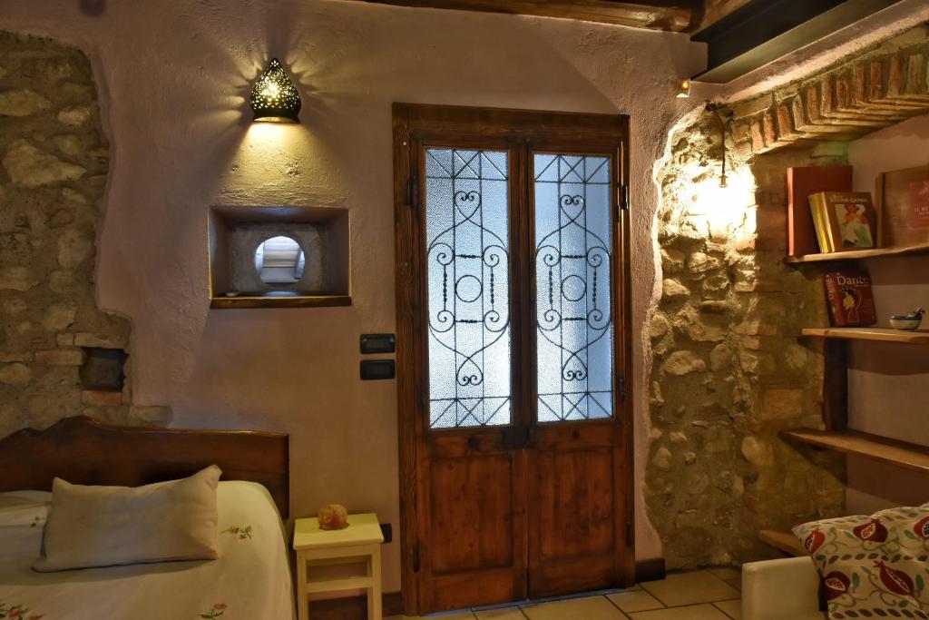 a bedroom with a wooden door and a window at B&B Il Melograno del Garda in Padenghe sul Garda