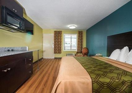 Habitación de hotel con cama grande y cocina en Royal Extended Stay Hotel, en Selma