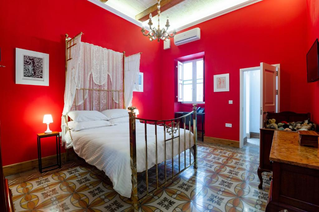 a bedroom with a bed in a red wall at Monreal Boutique Townhouse - R024RM4 in Paola