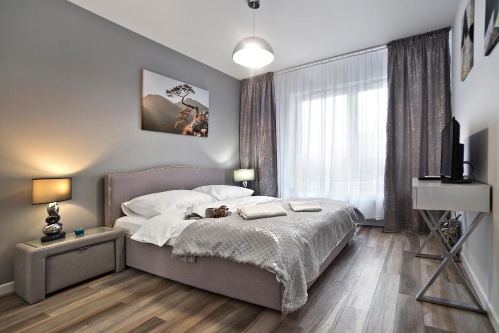 ein Schlafzimmer mit einem Bett mit zwei Handtüchern darauf in der Unterkunft Goclaw P&O Serviced Apartments in Warschau