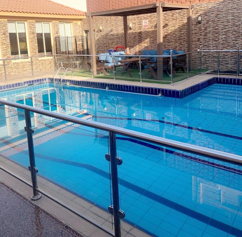 une grande piscine bleue avec une table. dans l'établissement جُمان للعائلات, à Djeddah