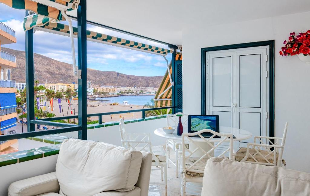 Cette chambre dispose d'un balcon avec une table et des chaises. dans l'établissement La Maricita Cristianos - Beach Front & Sea View, à Los Cristianos