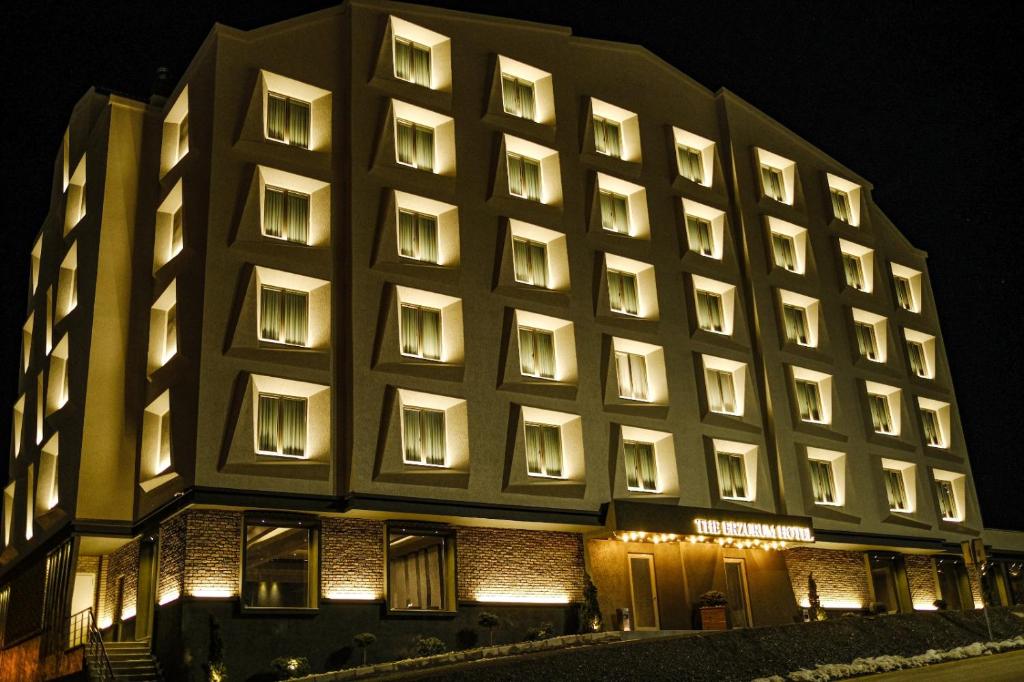 The Erzurum Hotel في أرزروم: مبنى كبير مع العديد من النوافذ في الليل