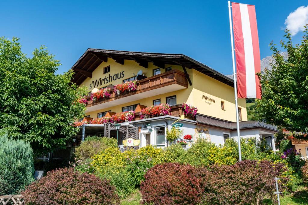 a building with flowers on the side of it at s'Wirtshaus by Alpine Genusswelten in Gröbming