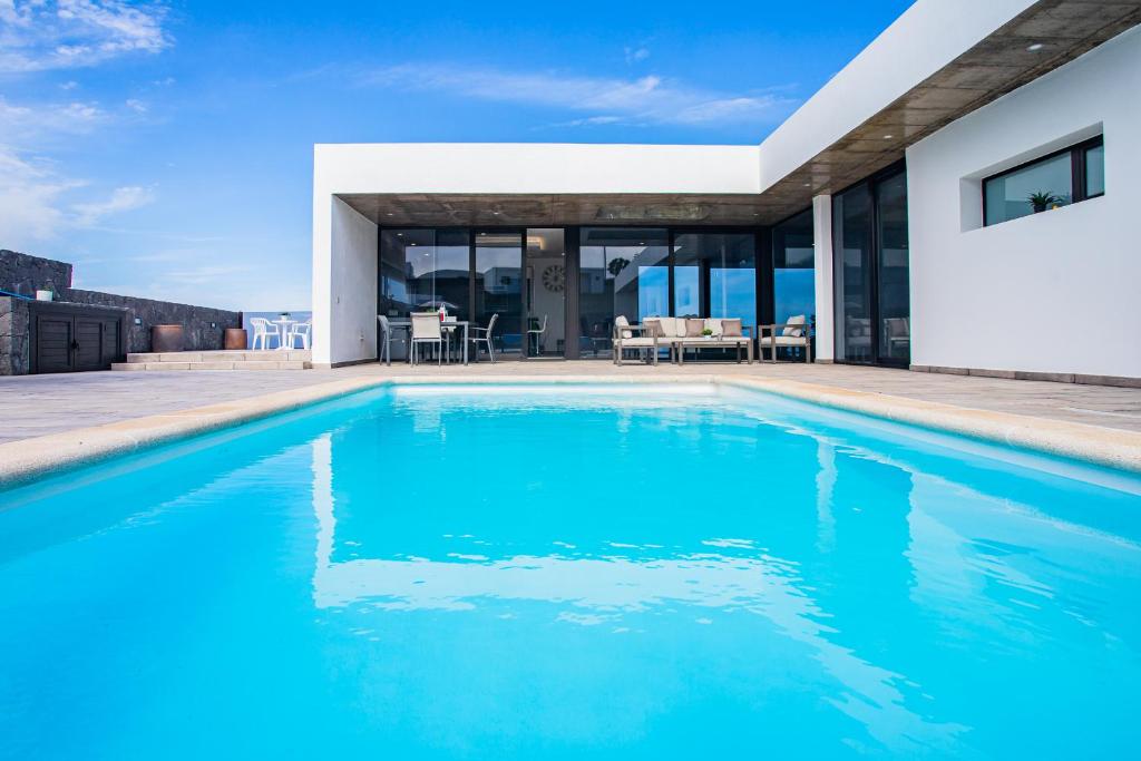 una piscina frente a una casa en Eslanzarote Eco Villa Tony, heated pool, jacuzzi, Sat tv, Super wifi, en La Costa