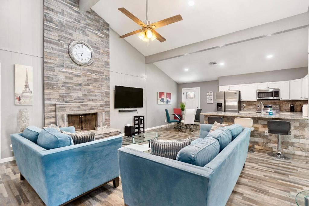 een woonkamer met twee blauwe banken en een open haard bij CYC Mega House with BBQ Gazebo in San Antonio