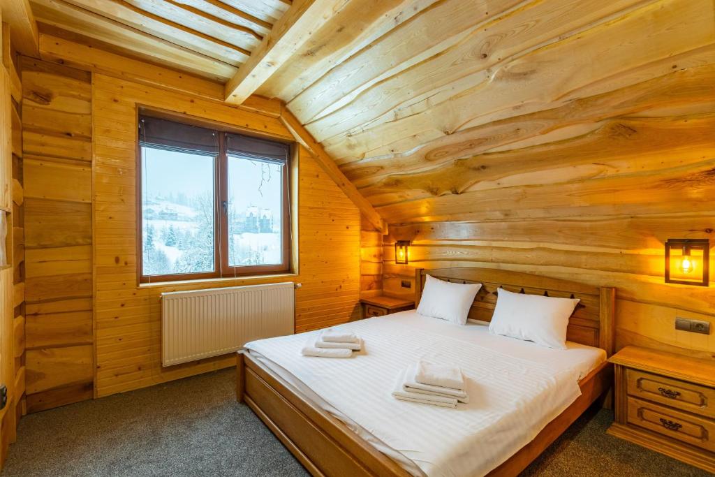 a bedroom with a bed in a wooden cabin at Rich OAK - Багатий Дуб in Yablunytsya