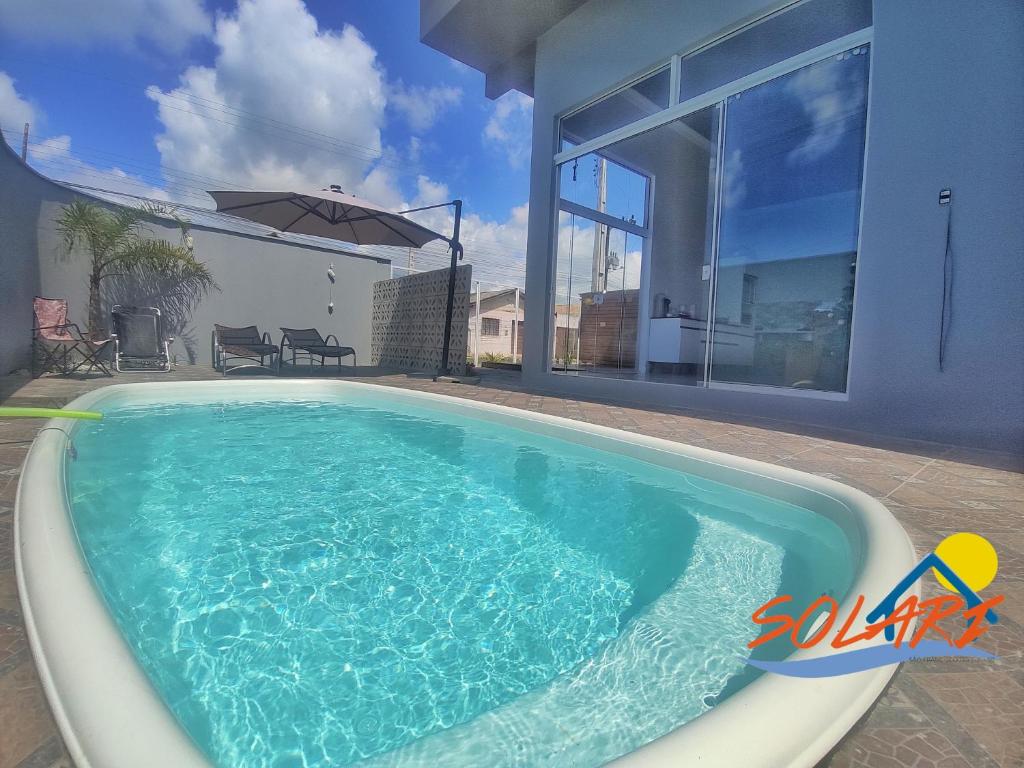 uma piscina em frente a uma casa em Pousada Solari em São Francisco do Sul