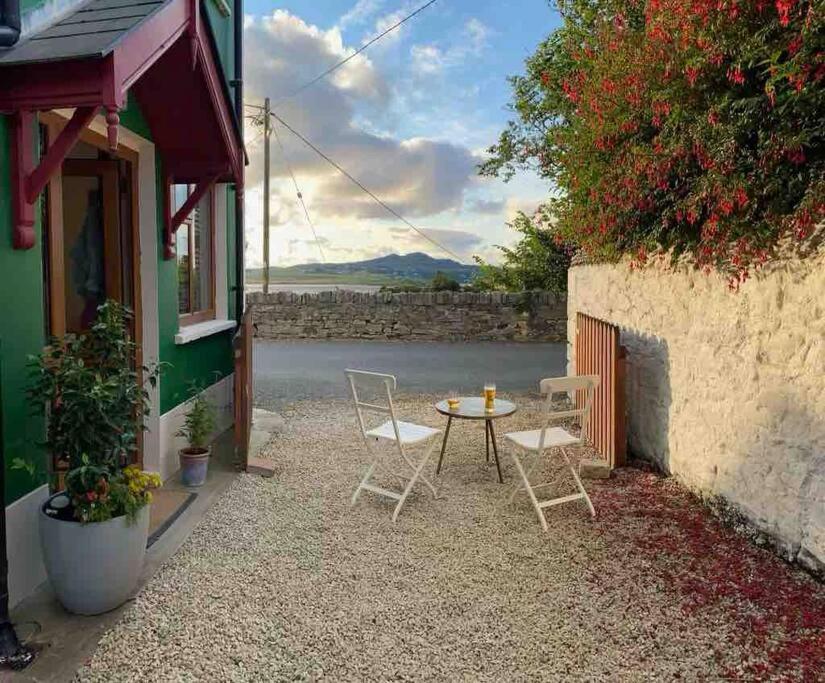 a small patio with a table and chairs in front of a building at The Historic Wee Green House in Carrigart