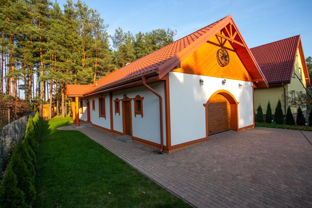 ein kleines Haus mit orangefarbenem Dach in der Unterkunft DOMINIÓWKA in Prostki
