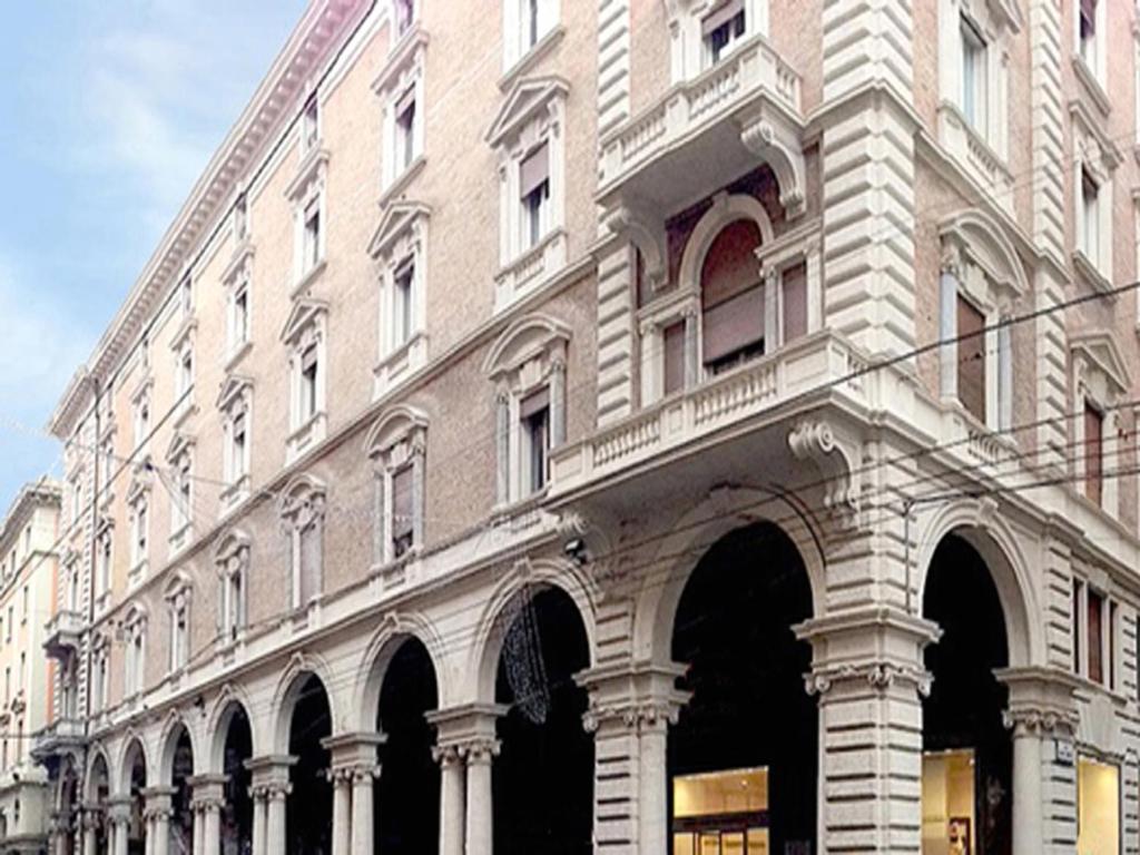 un gran edificio de ladrillo con arcos en una calle en Alle Torri, en Bolonia