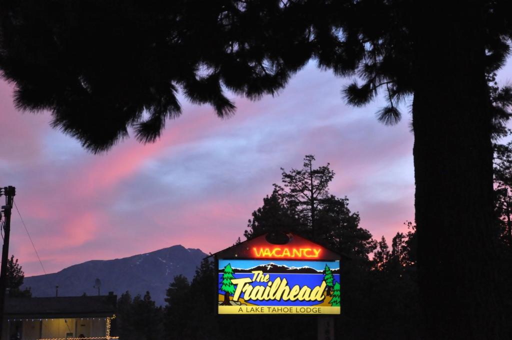 un signo de evaluación con una puesta de sol en el fondo en The Trailhead, en South Lake Tahoe