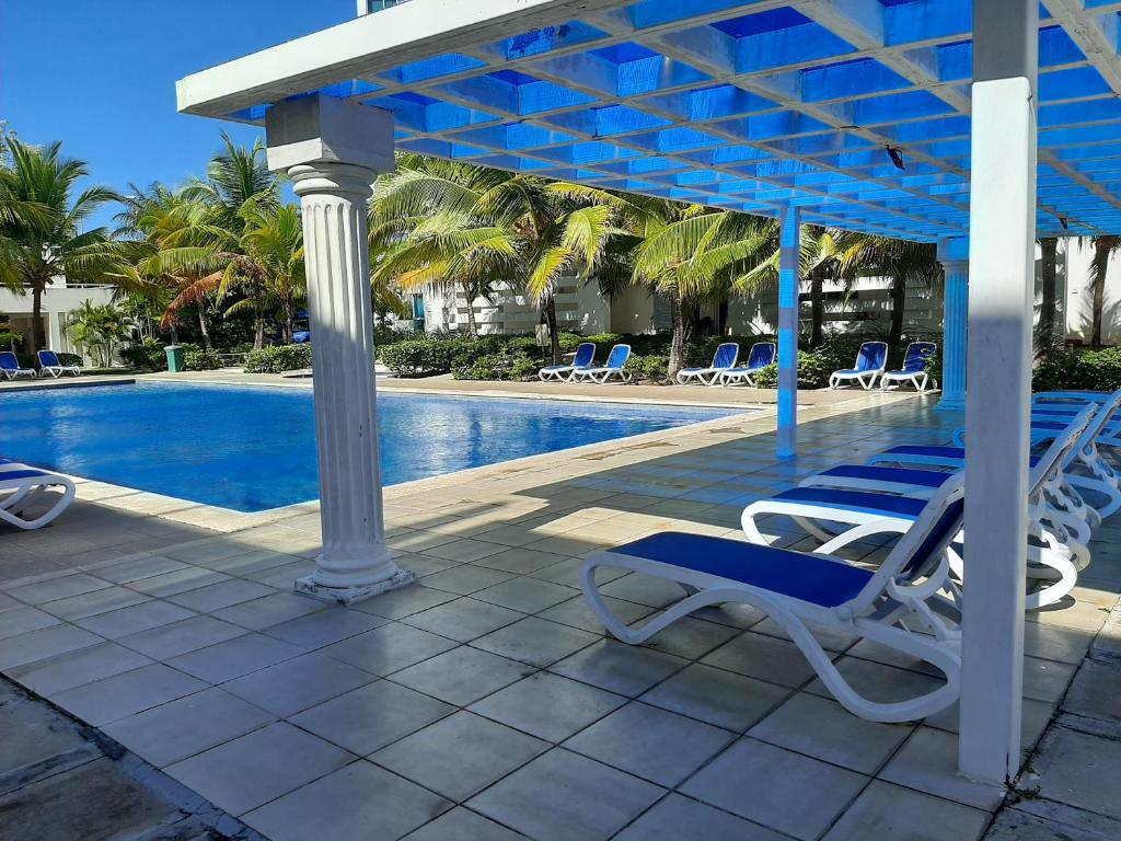 a patio with chairs and a swimming pool at Relajate en un hermoso apartamento Duplex cerca de la playa y piscina en Playa Blanca, Farallon in Río Hato