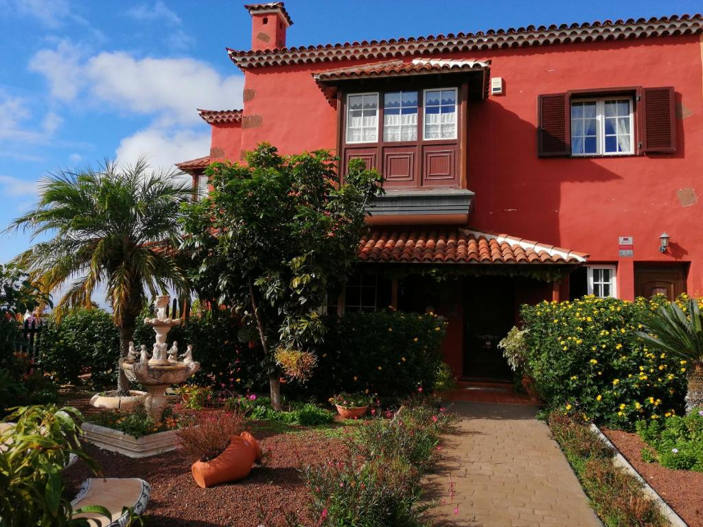 una casa roja con un jardín delante en Villa La Victoria, en Tegueste