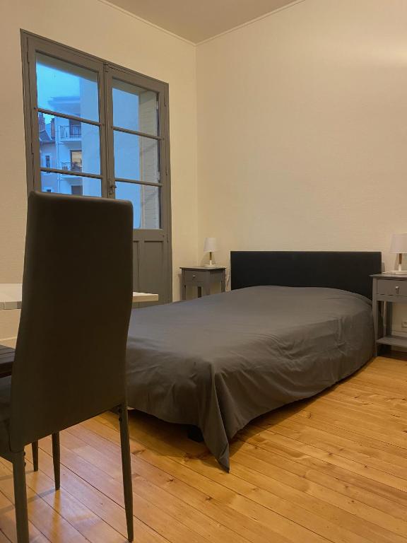 une chambre avec un lit et une grande fenêtre dans l'établissement Le Semnoz, à Annecy