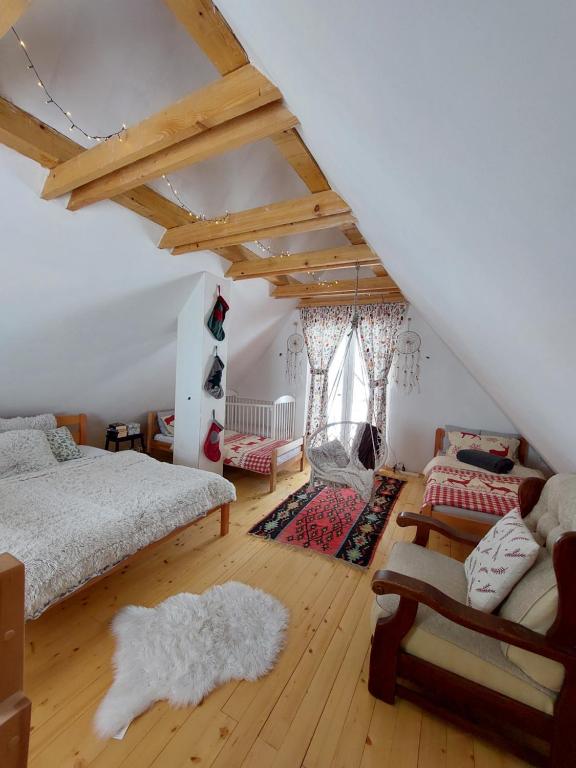 Cette chambre mansardée comprend deux lits et un canapé. dans l'établissement Planinska kuca Bjelasnica, à Sinanovići