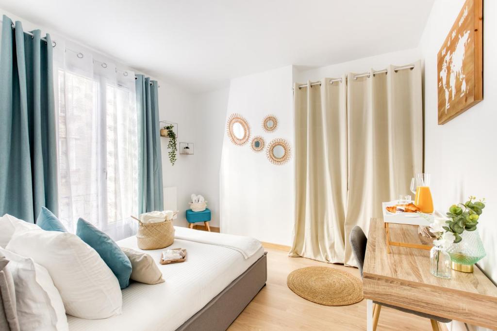 ein Wohnzimmer mit einem weißen Sofa und einem Fenster in der Unterkunft Grand Line - Parking- Métro 5 - Easy Check-in - Netflix - Disney Plus in Pantin