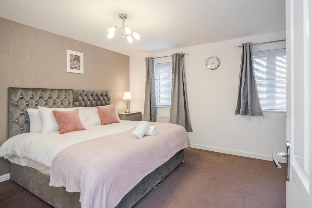 een slaapkamer met een groot bed en een raam bij Stunning 3BR house in Basildon in Basildon