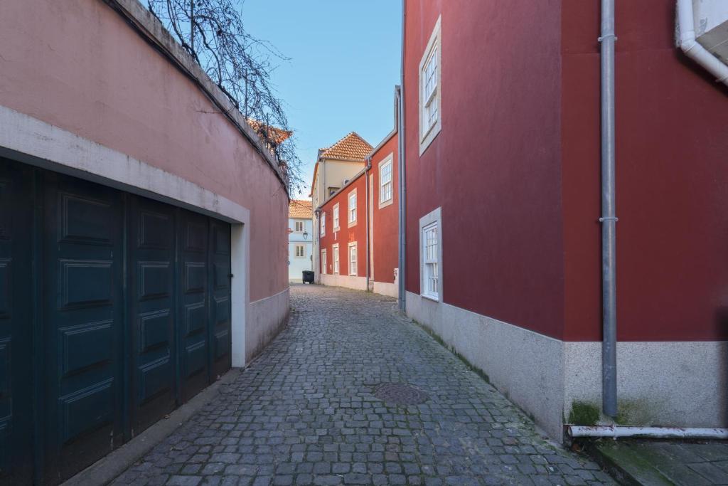 um beco vazio com edifícios vermelhos e uma garagem em Habitatio - Foz no Porto