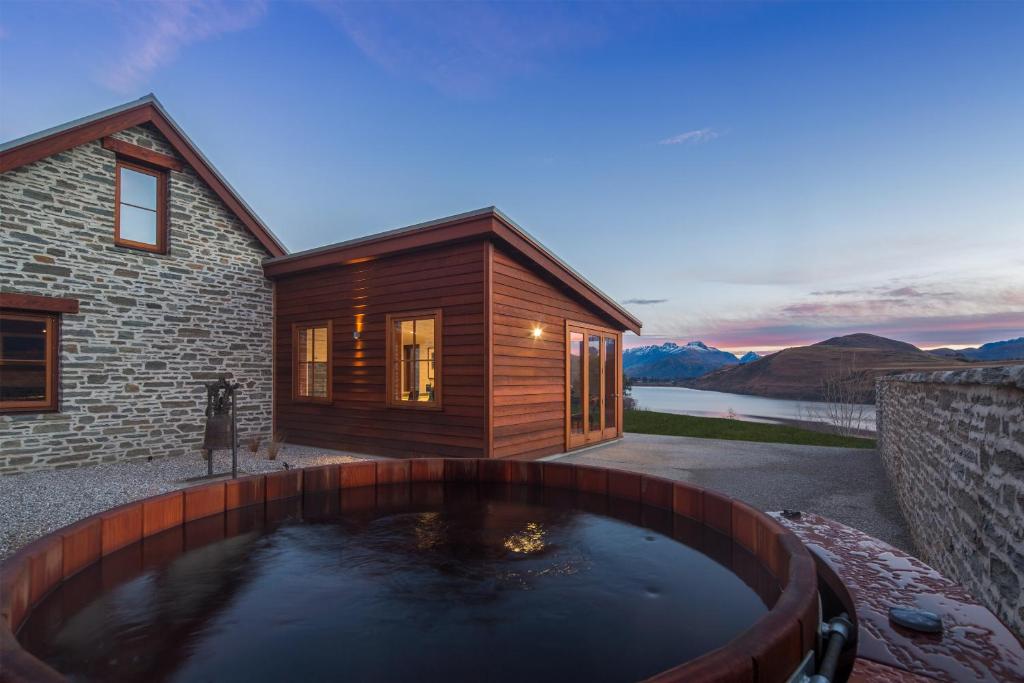 duży basen z wodą przed domem w obiekcie The Homestead on Wilding by Sotheby's Luxury Rental Homes w mieście Arrowtown
