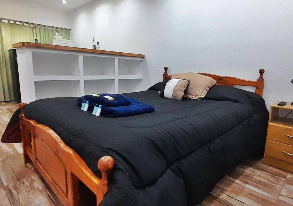 sypialnia z dużym łóżkiem z czarną kołdrą w obiekcie Departamento en El Calafate para dos personas w mieście El Calafate