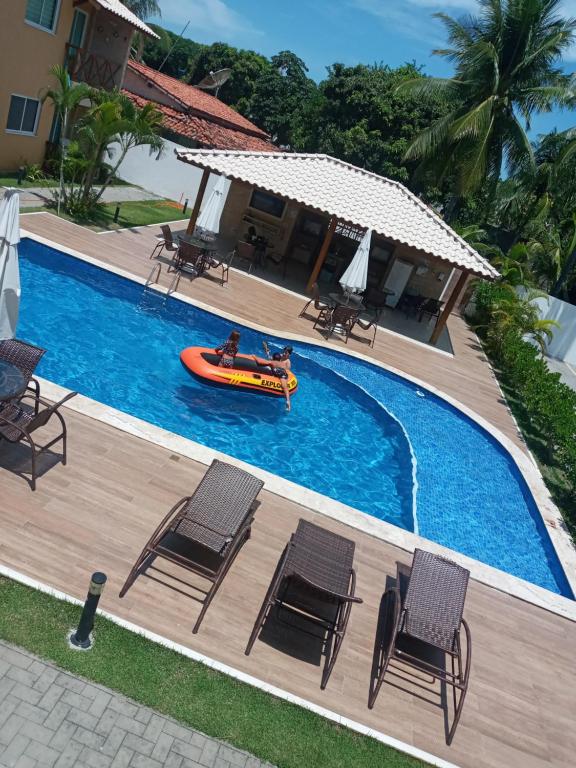 uma imagem de uma piscina com um barco em Guarajuba! Excelente localização, Lindo, confortável e decorado! em Guarajuba