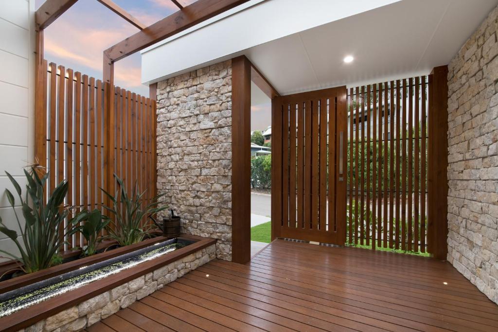 an external view of a house with a wooden deck at Luxury Villa Townsville in Belgian Gardens