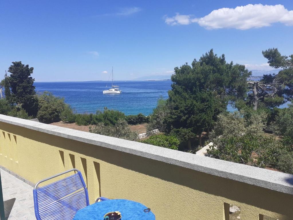 a blue chair on a balcony with a view of the ocean at Apartment Brane - charming and close to the sea in Sutomišćica