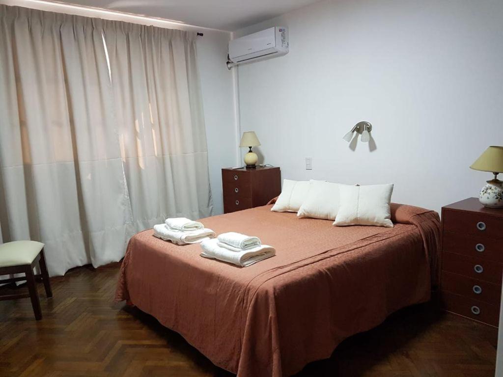 a bedroom with a bed with towels on it at Balcón de los Campanarios in Salta