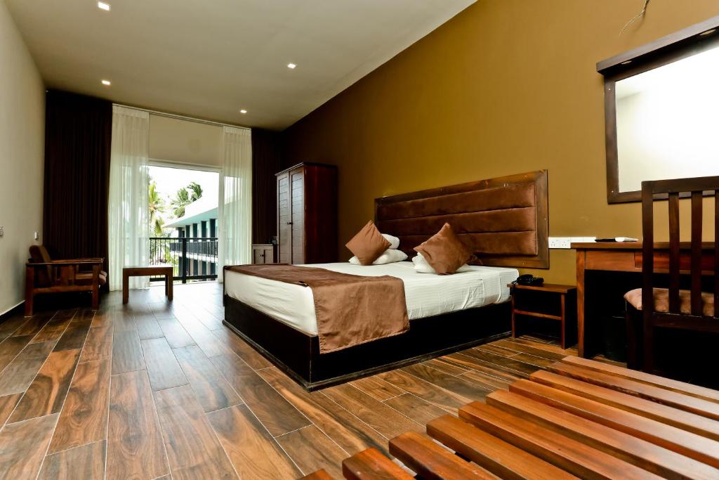 een slaapkamer met een bed en een projectiescherm bij Golden Star Beach Hotel in Negombo