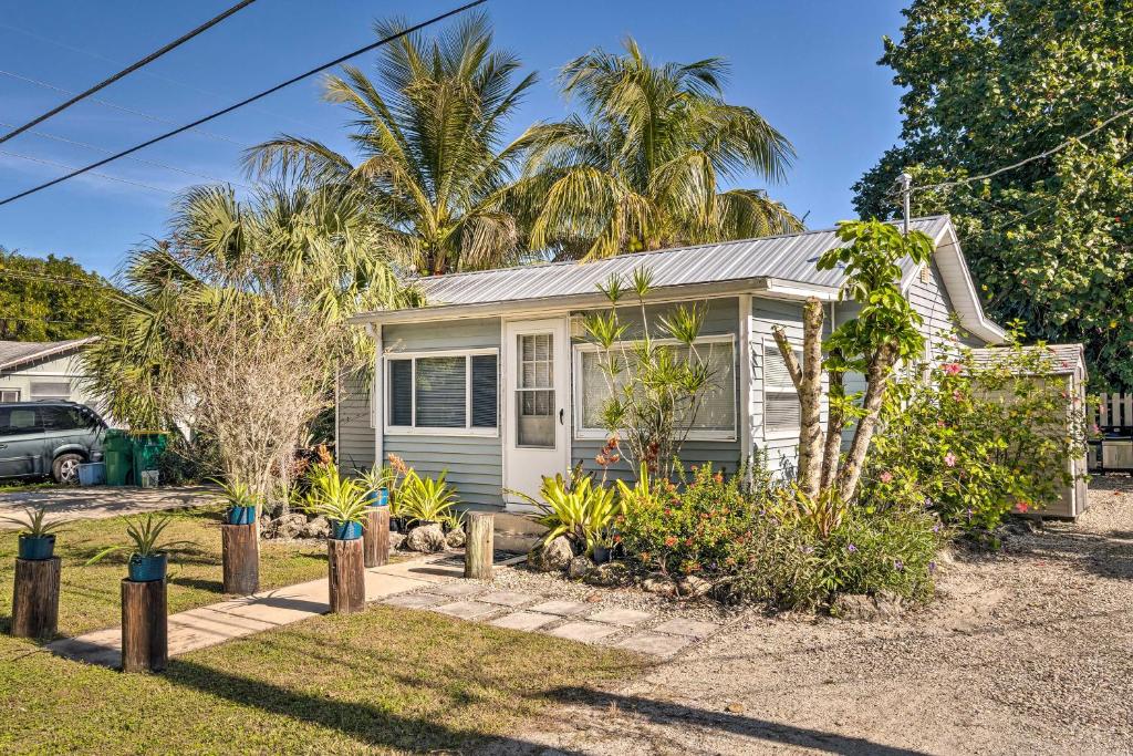 a small house with palm trees in front of it at Tropical Port Charlotte Cottage - Walk to Bay! in Port Charlotte