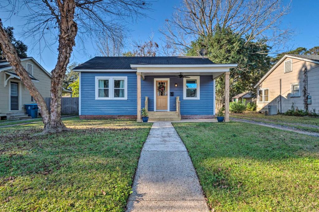 una casa azul con una acera delante de un patio en Central Cottage with Grill, 1 Mi to Cajun Field en Lafayette