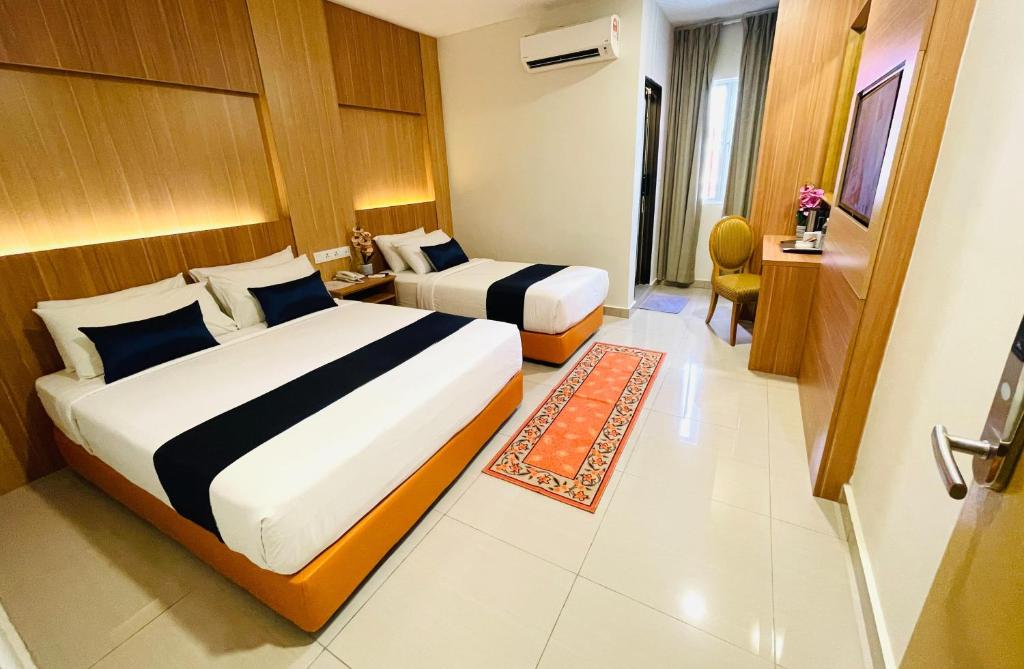 a hotel room with two beds and a television at Easy Hotel KL Sentral in Kuala Lumpur