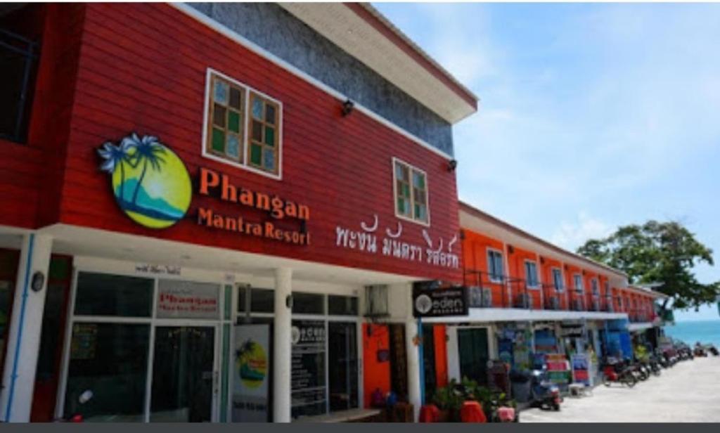 un edificio rojo con un cartel en el costado en Phangan Mantra Inn, en Haad Rin