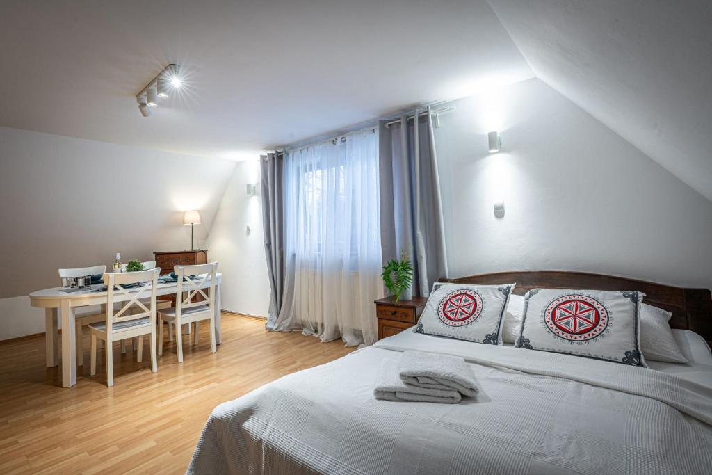 a bedroom with a bed and a table and a desk at Willa Cicha Woda III in Zakopane