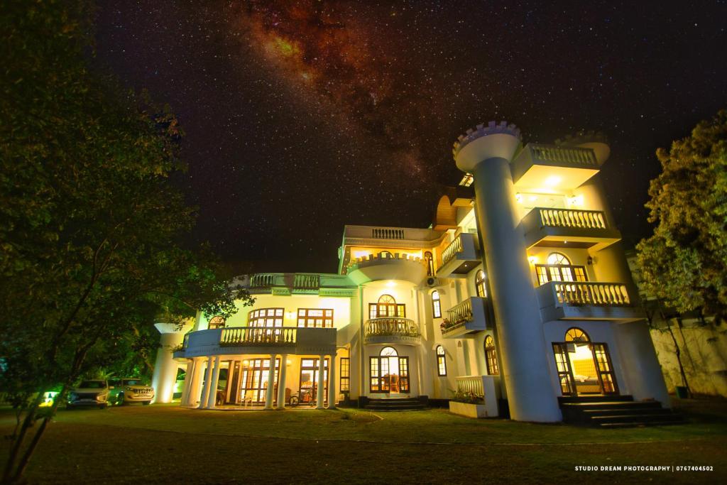 uma grande casa branca à noite com um céu estrelado em Tiverton Homestay em Godagandeniya