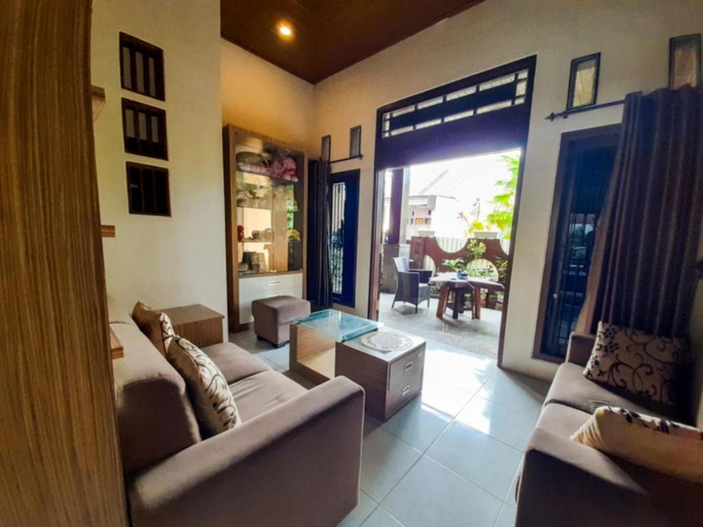 a living room with a couch and a glass table at Mocca Guest House in Banyuwangi